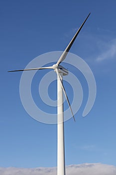 A large three blade industrial wind turbine generating electricity