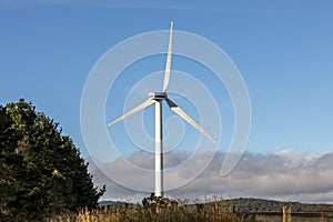 A large three blade industrial wind turbine generating electricity