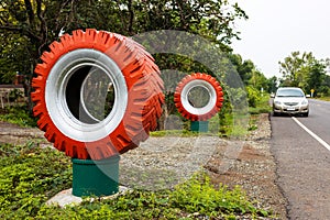 Large tires painted in orange and white decorate the roadside