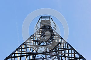 Large tower of metal structures against the blue sky. Metal construction.