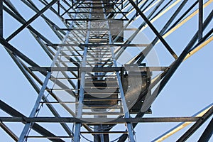 Large tower of metal structures against the blue sky. Metal construction.