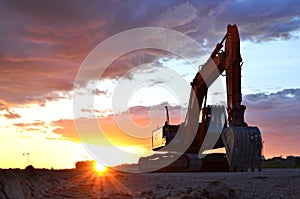 Large tracked excavator on a construction site against the background of the  awesome sunset.