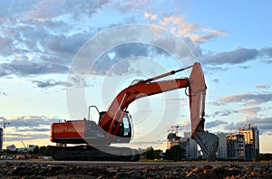 Large tracked excavator on a construction site background of the  awesome sunset.