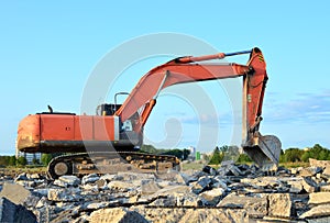 Large tracked excavator works in a gravel pit. Loading of stone and rubble for its processing at a concrete factory