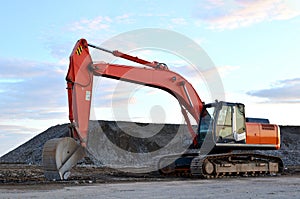 Large tracked excavator works in a gravel pit. Loading of stone and rubble for its processing at a concrete factory into cement