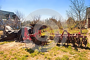 large tractor-drawn plough seeder in country garden in spring