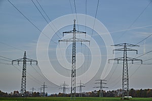 Large transmission towers in the countryside. Different types of electricity pylons in the countryside. Large electricity poles in