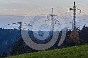 Large transmission towers in the countryside. Different types of electricity pylons in the countryside. Large electricity poles in