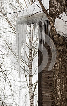 Large transparent icicles hang from the edge of the roof.