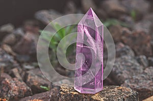 Large transparent mystical faceted crystal of colored pink amethyst, chalcedony on a stone background close-up. Wonderful mineral