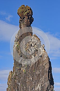 Large triangular seastack against blue sky