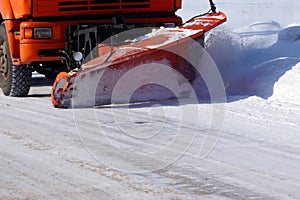 A large truck clears snow from the road