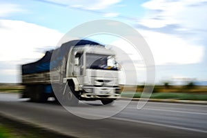Large truck passing by with a panning speed effect on the road