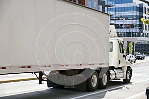 A large truck with a semitrailer in city traffic. A city on the east coast of the USA