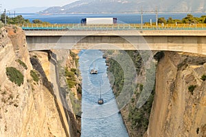 Large truck traversing the bridge of isthmus of Corinth in Greece while the boats are travelling in the bottom.
