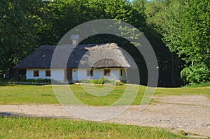 Large Ukrainian hut with a straw roof and wooden windows