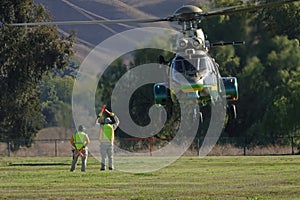 Large Utility Helicopter Landing in a Field with Ground Crew