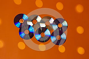 Large Variety of Arranged CD Disks or DVD Disks on Orange Background With Different Circular Dotted Patterns or Masks