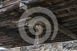 Large vertical megalith supporting an old wooden house