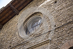 Large vintage round window with bars. Decorative element of an old renaissance building.