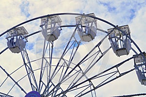 Large vintage style ferris wheel against a sky with broken clouds