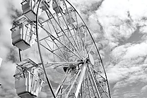 Large vintage style ferris wheel against a sky with broken clouds