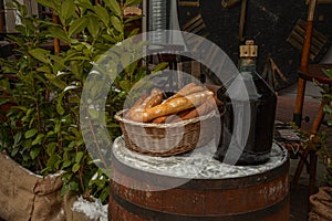 Large Vintage Wine Bottles in wicker basket on a barrel