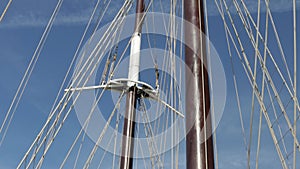 A large vintage wooden yacht sails on the sea. View of the bow of the yacht with furled sails.