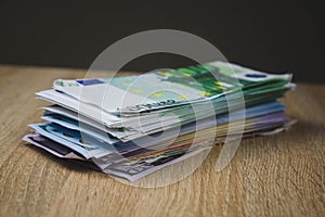 a large wad of cash bills dollar euro rubles in packs on a table of textured boards