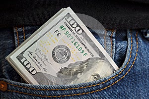 large wad of hundred-dollar bills protrudes from pocket of jeans. Concept of cash bribery. All money earned is all given for