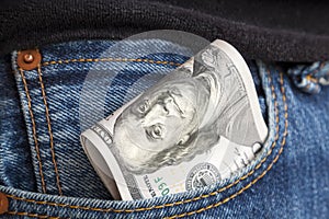 large wad of hundred-dollar bills protrudes from pocket of jeans. Concept of cash bribery. All money earned is all given for