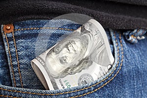 large wad of hundred-dollar bills protrudes from pocket of jeans. Concept of cash bribery. All money earned is all given for