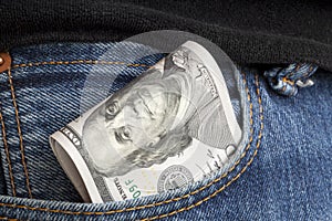 large wad of hundred-dollar bills protrudes from pocket of jeans. Concept of cash bribery. All money earned is all given for
