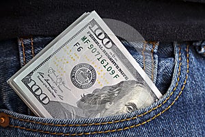 large wad of hundred-dollar bills protrudes from pocket of jeans. Concept of cash bribery. All money earned is all given for