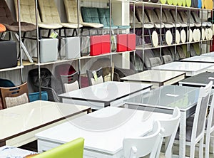 A large warehouse of chairs and tables in a shopping center. Sale of tables and chairs. Different types of chairs in the interiors