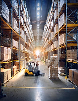 A large warehouse filled with stacked pallets and a forklift operator at work