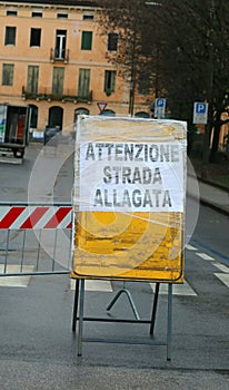 Large warning sign with big text in italian language that means CAUTION FLOODED ROAD photo