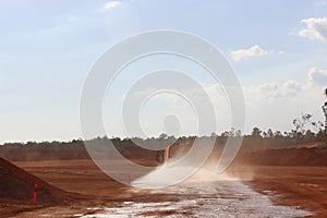 Large water truck spaying water on red road near Weipa FNQ Australia photo