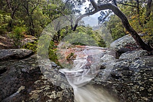 a large waterfall next to a rock in patonga