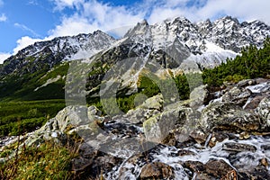 Large Waterfall from ravine in autumn, long exposure with mountains in background