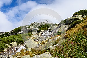 Large Waterfall from ravine in autumn, long exposure with mountains in background