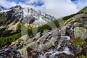 Large Waterfall from ravine in autumn, long exposure with mountains in background