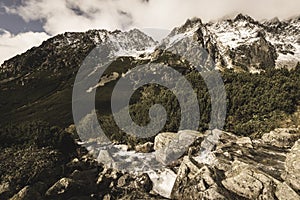 Large Waterfall from ravine in autumn, long exposure with mountains in background - vintage film look