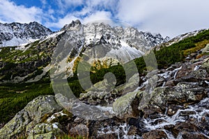 Large Waterfall from ravine in autumn, long exposure with mountains in background