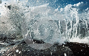 Large Waves Crash into Rock Tide pools, Throwing Foamy White Seawater Spray Into The Air In Storm