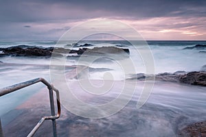 Large waves engulf the public rock pool in Bermagui