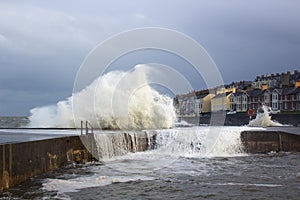 Large waves from the Irish Sea during a winter storm batter the harbor wall at the long Hole in Bangor Ireland