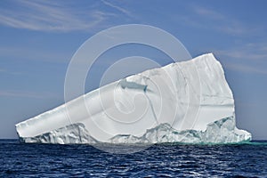 Large wedge shaped iceberg marooned in sea