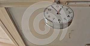 A large white analog clock hangs from the ceiling.