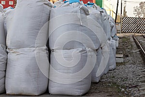 Large white bags of salt lie on the street. Industrial fertilizers are stored in bags